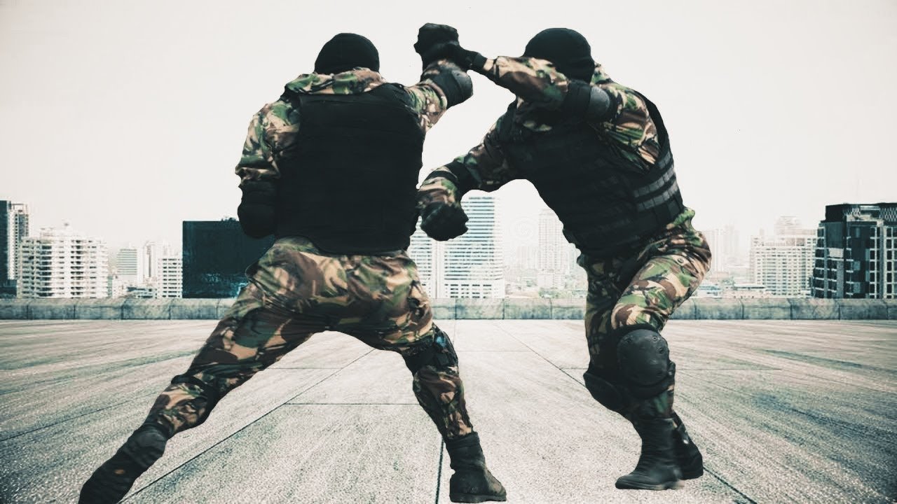 Żołnierze w maskowaniu walczą wręcz na dachu budynku w mieście, otoczeni wieżowcami.