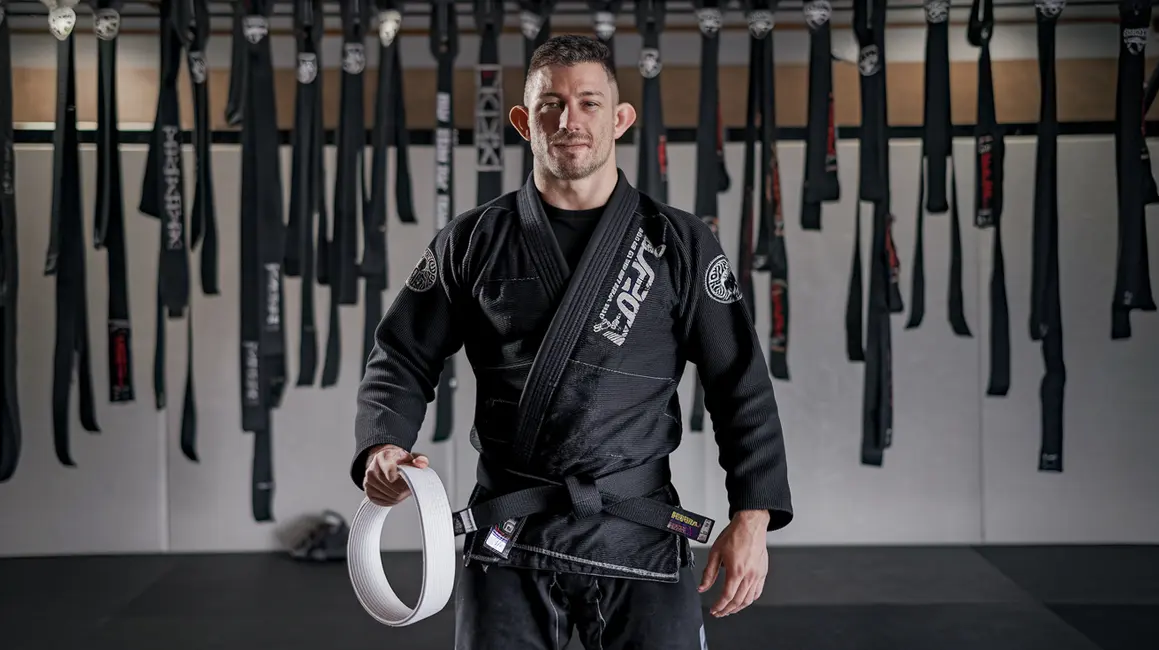 Zbiór pasów BJJ w dojo, symbolizujący osiągnięcia zawodników