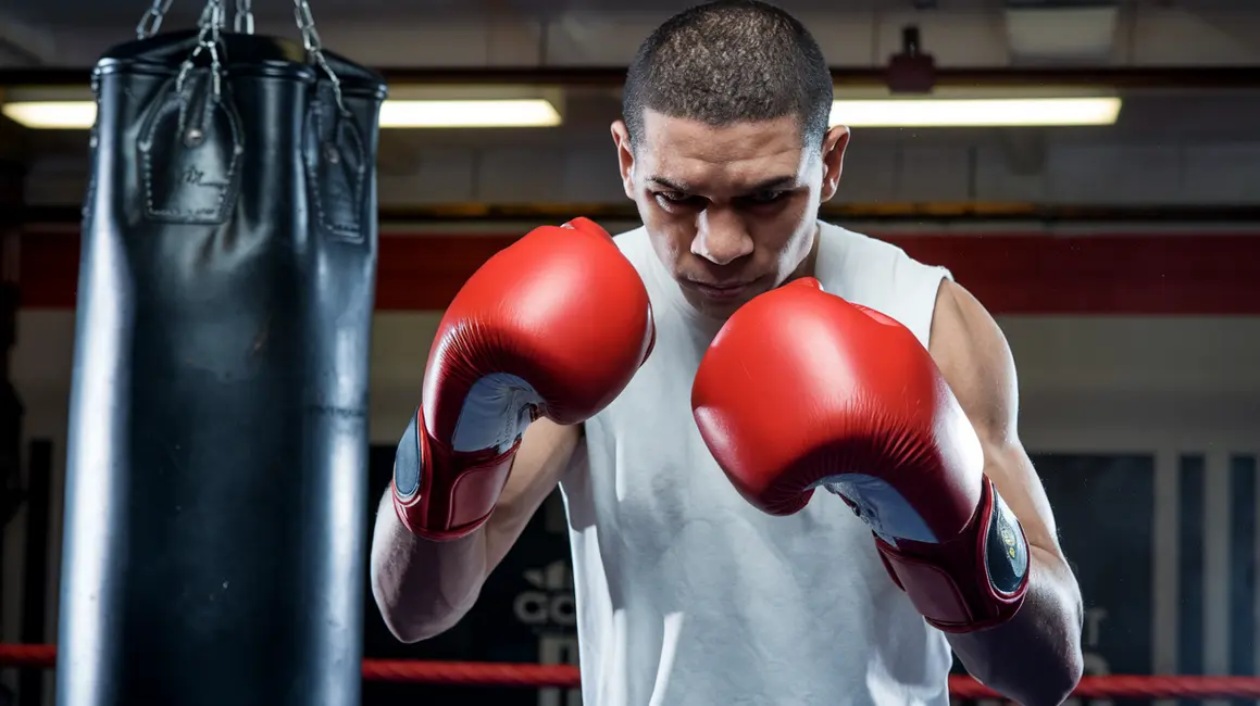 Bokser w rękawicach, gotowy do wykonania prawidłowo zaciśniętej pięści.
