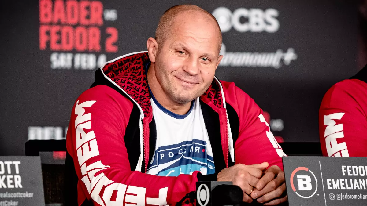 Fedor Emalienko w czerwonej bluzie siedzi przy stole z mikrofonem. W tle napisy: "BADER vs FEDOR 2", "CBS", "Paramount+", "SAT FEB 4".