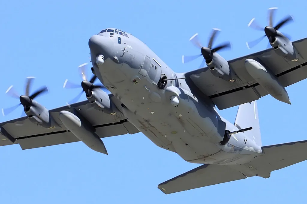 Samolot AC-130 w locie – czterosilnikowy gunship na tle błękitnego nieba.