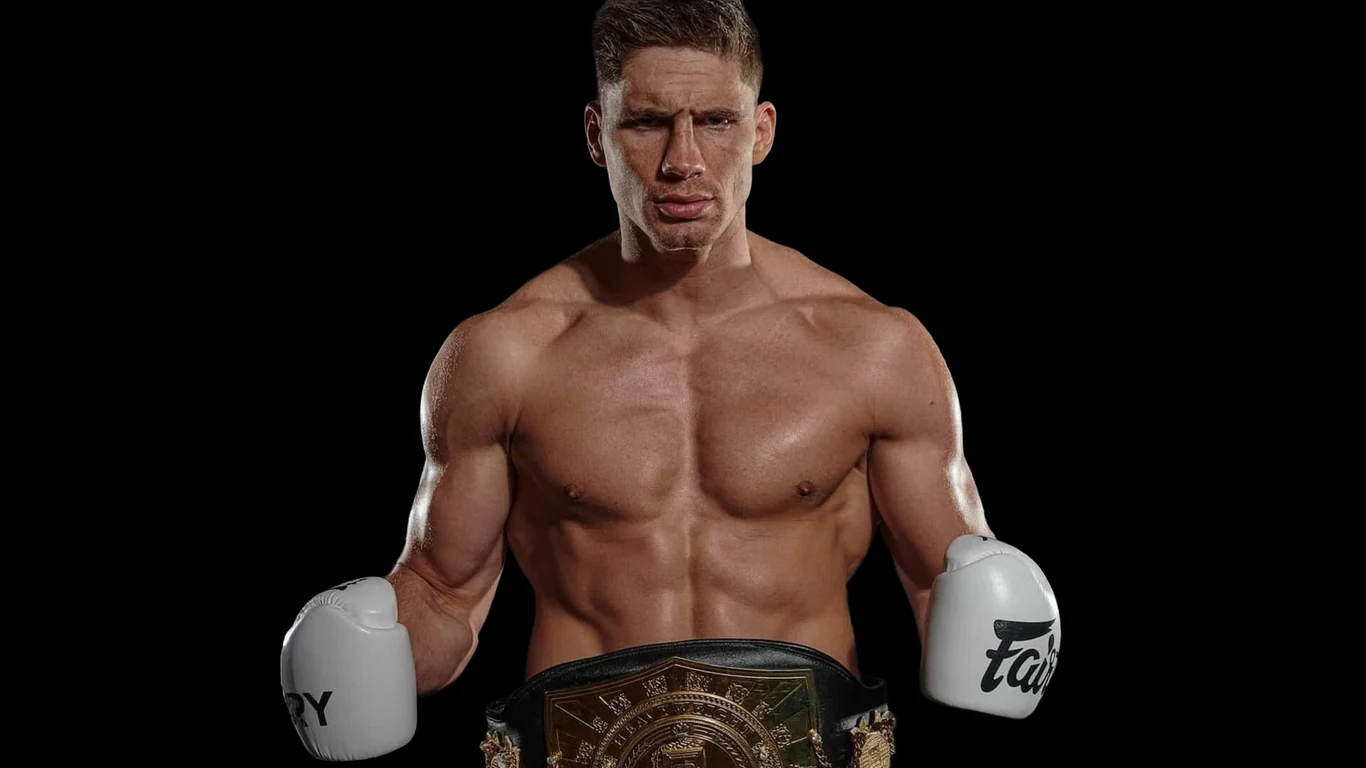 Rico Verhoeven z pasem mistrza Glory wagi ciężkiej i białymi rękawicami bokserskimi