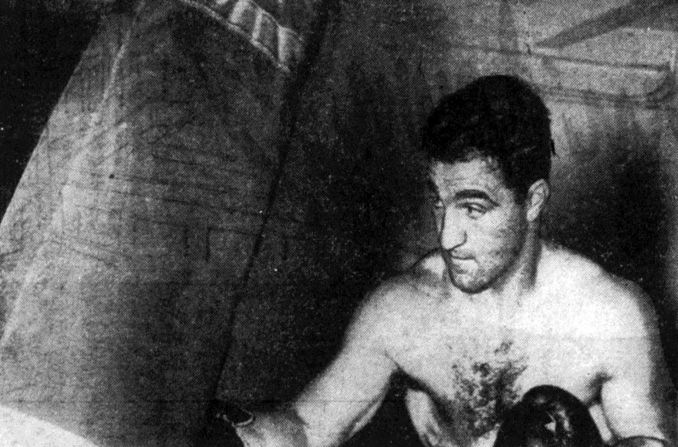 Rocky Marciano trenuje przy worku bokserskim, bez koszulki
