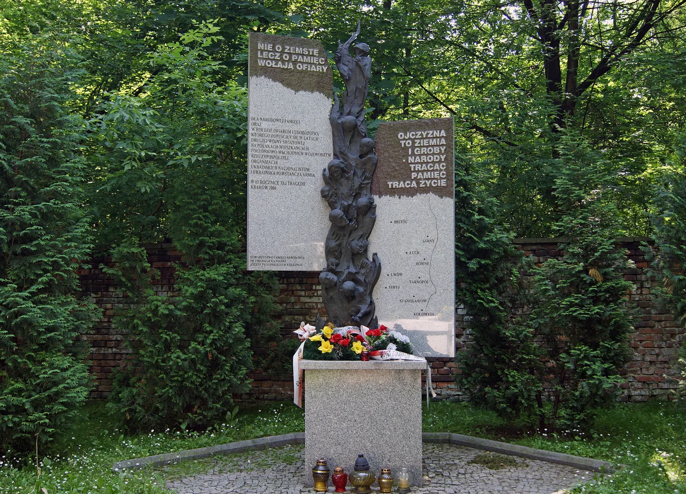Pomnik ofiar rzezi wołyńskiej w Krakowie z rzeźbą splecionych postaci i mapą Kresów Wschodnich