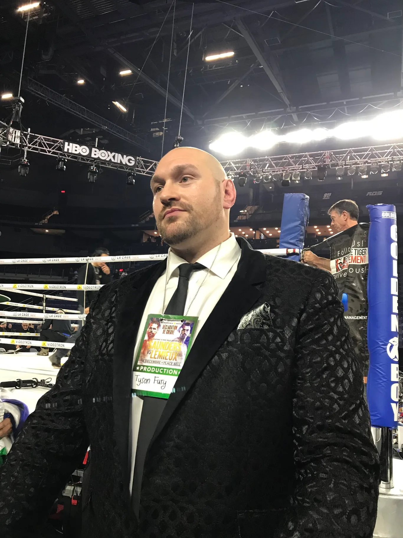 Tyson Fury w czarnym garniturze przy ringu bokserskim pod bannerem HBO Boxing