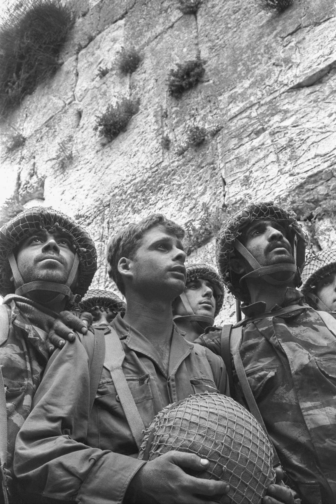 Trzej izraelscy spadochroniarze patrzą w górę pod Murem Zachodnim w Jerozolimie w 1967 roku
