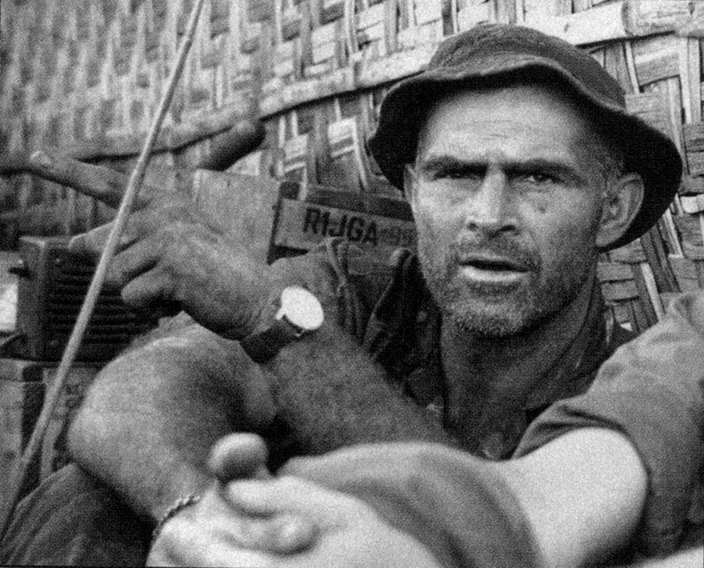 Czarno-biały portret uśmiechniętego oficera w kapeluszu polowym i mundurze z naszywkami US Army