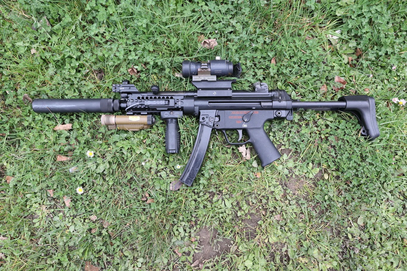 Pistolet maszynowy HK MP5 używany przez GIGN, wyposażony w tłumik, celownik optyczny, latarkę taktyczną i chwyt przedni