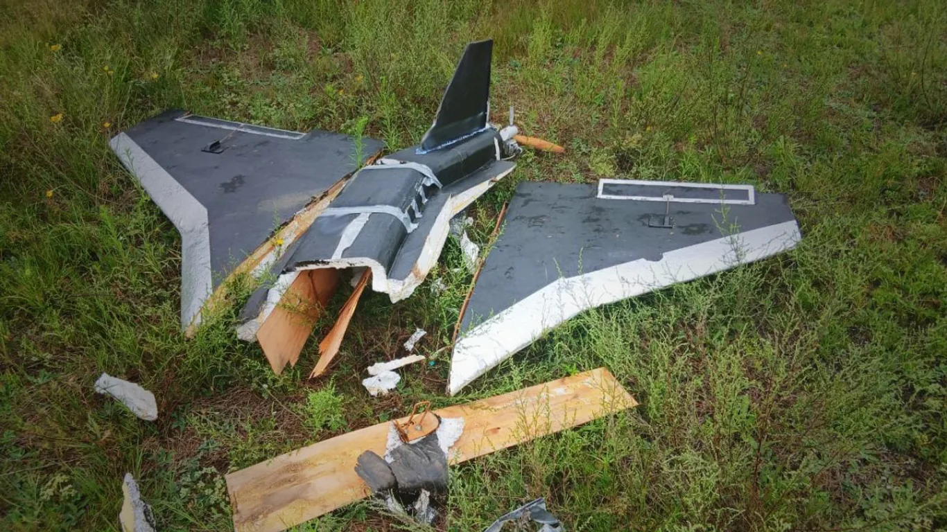 Rozbity rosyjski dron Gerbera leżący w trawie – widoczne skrzydła w układzie delta, pęknięty kadłub z pianki i elementy ze sklejki